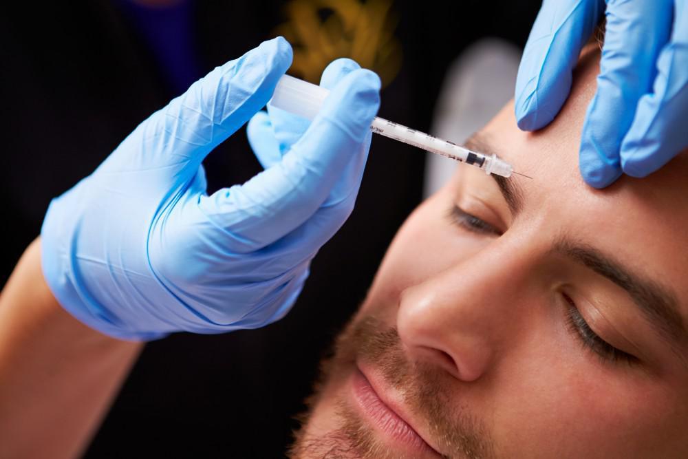 Man receiving a dose of Botox in forehead