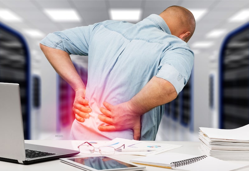 Man in office with lower back pain.